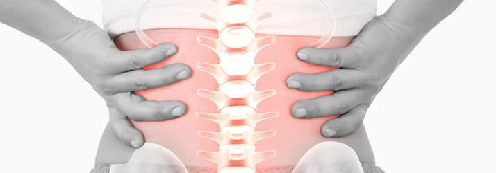 Hands holding lower back with highlighted spine indicating pain or discomfort.